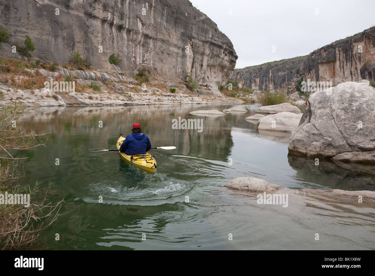 Solo kayaker paddles through canyon along the Pecos River arm of Lake