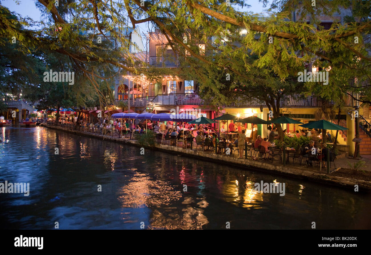 Restaurant on edge of river at dusk San Antonio River Walk Texas USA