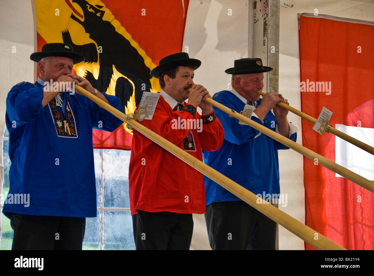 Men playing alphorn or alpenhorn or alpine horn at the Wengen Cheese