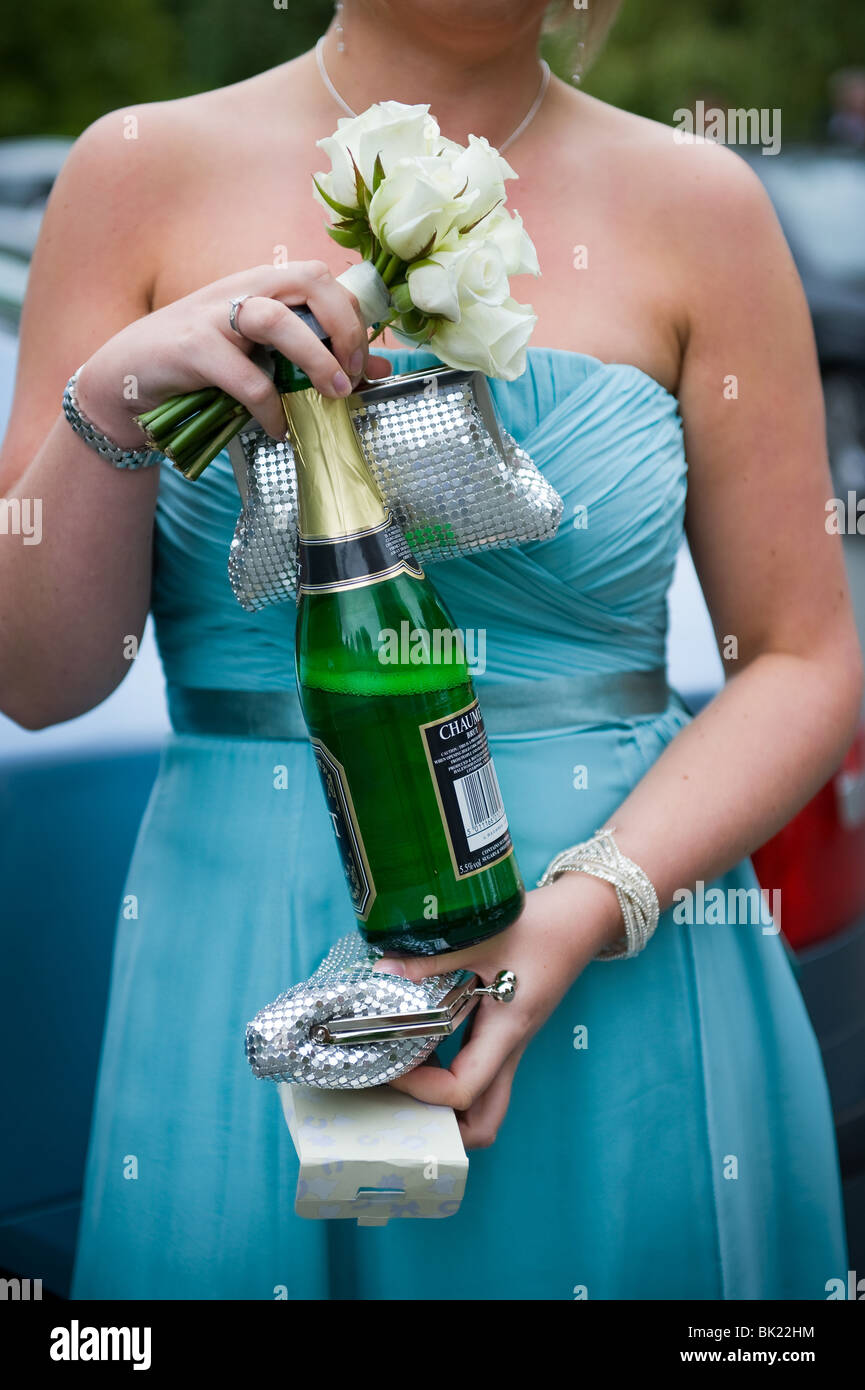 bridesmaid holding bouquet, purse, champagne and confetti Stock Photo