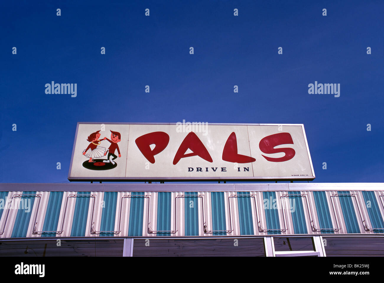 Illuminated 'Pals' sign at a drive-in, USA, c.1958, featuring a couple jiving on a record disk Stock Photo