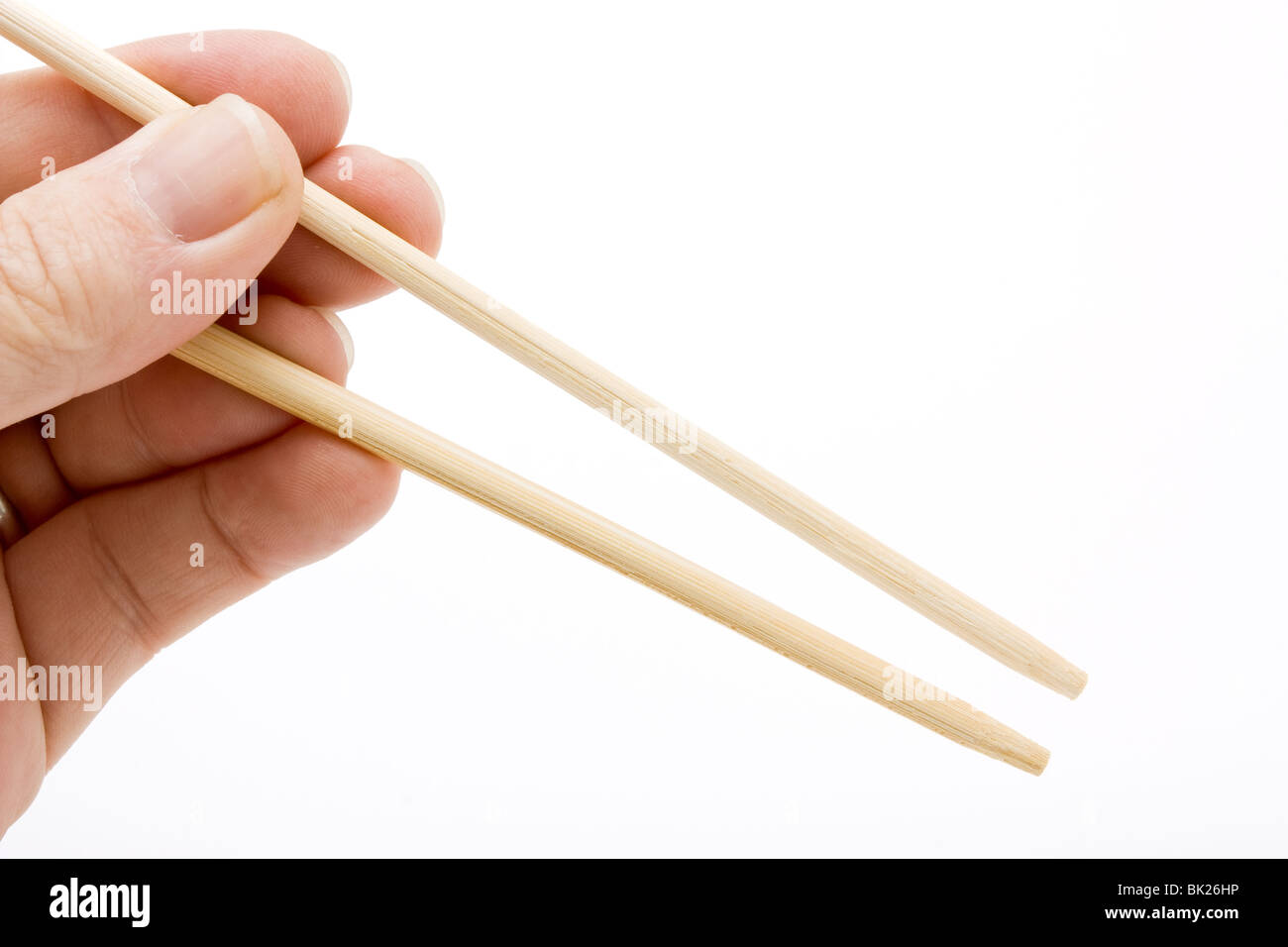 Hand Gesture holding a pair of empty chopsticks to add your own item against white. Stock Photo