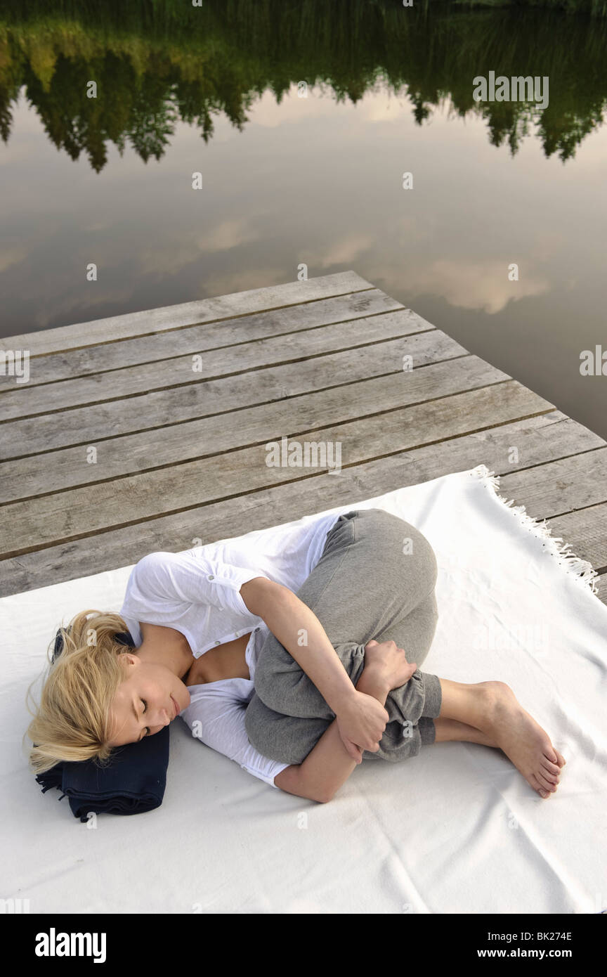 Young woman lying on blanket by lake Stock Photo Alamy