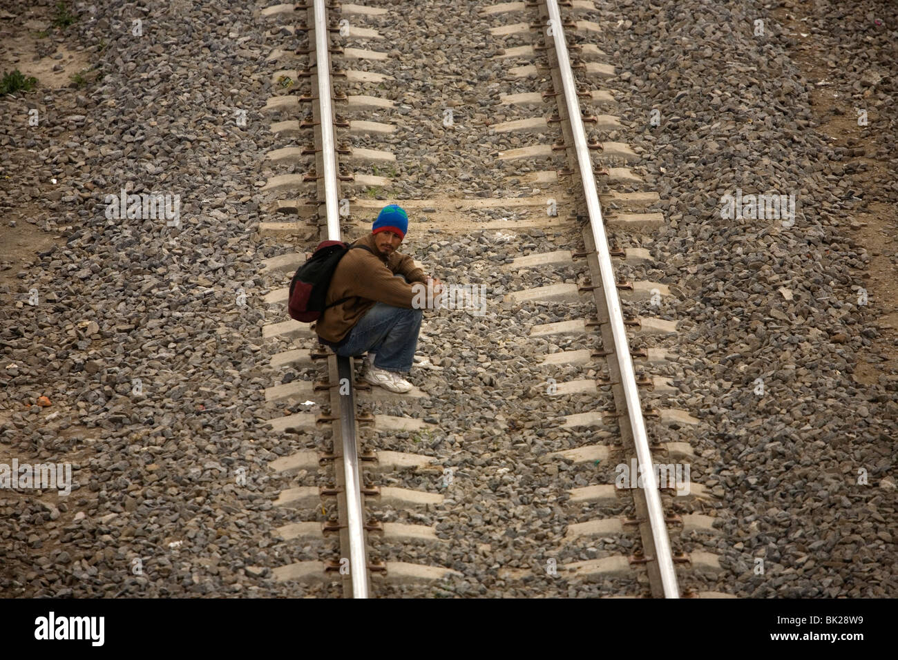 An undocumented migrant traveling across Mexico to work in the United States waits to jump a train in Mexico City, Mexico Stock Photo