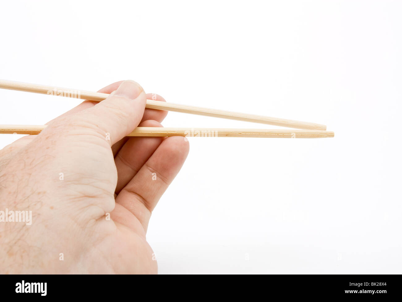 Hand Gesture holding a pair of empty chopsticks to add your own item against white. Stock Photo