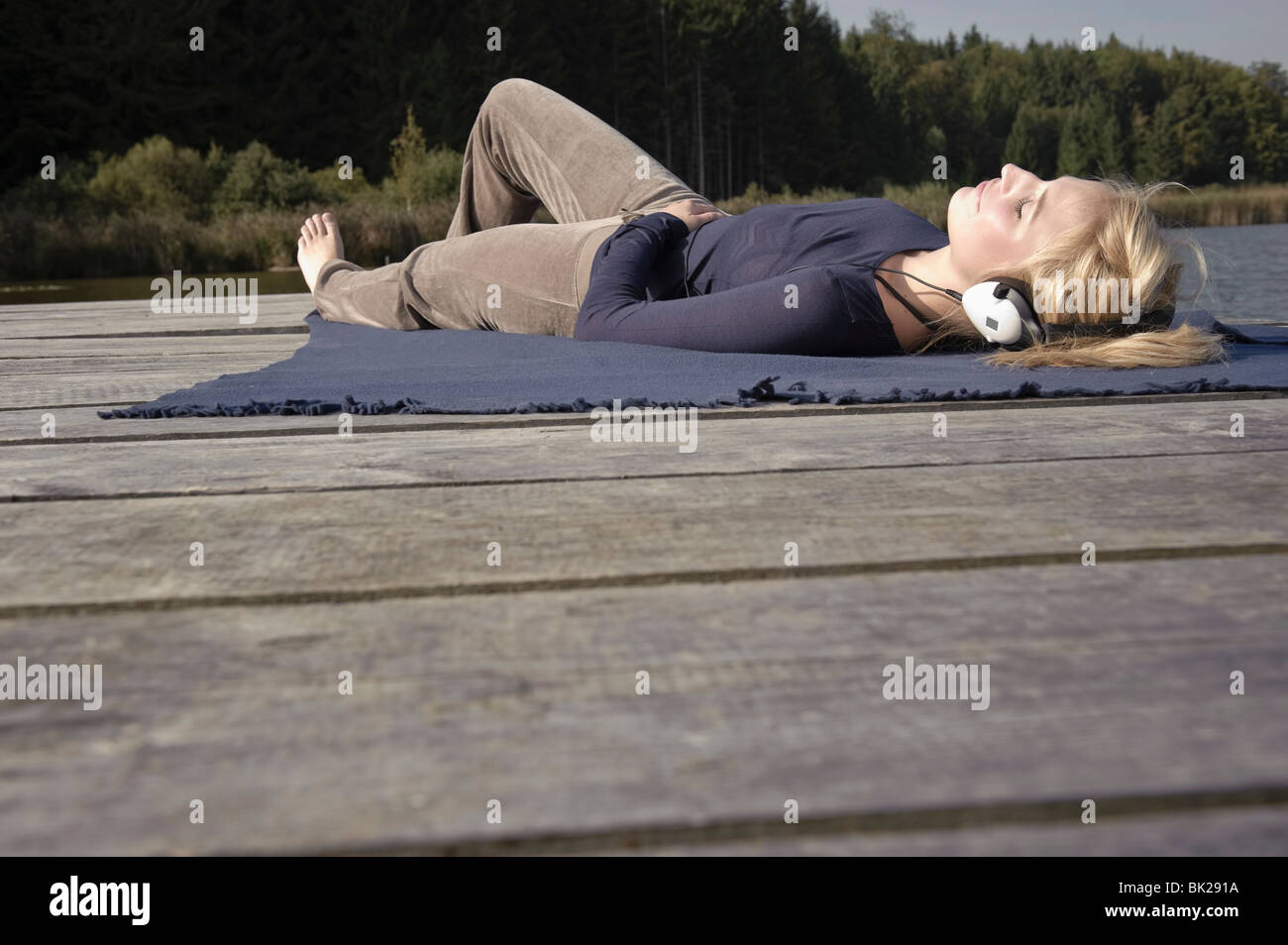 Young woman lies on blanket on jetty Stock Photo Alamy