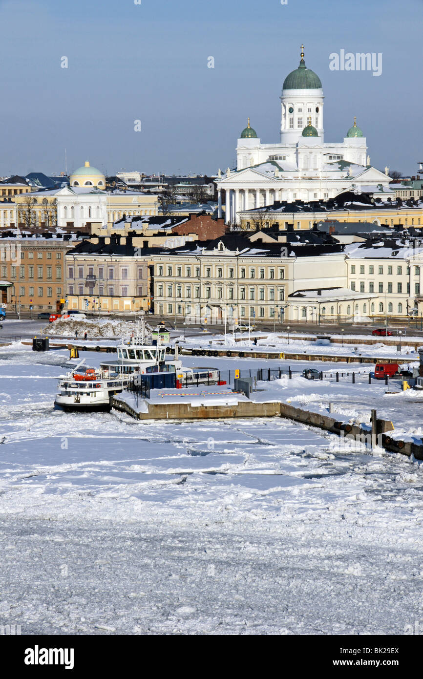 Ice covered Helsinki Harbour with Suomenlinna II berthed in the foreground and Helsinki Lutheran Cathedral raising up behind. Stock Photo
