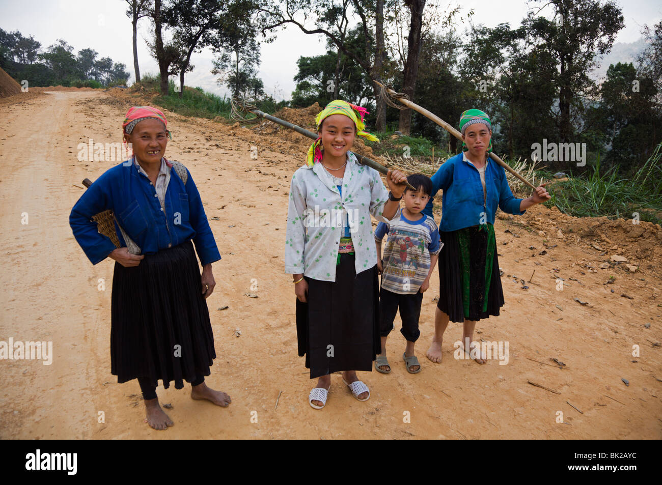 Blue Hmong women coming back from working in their fields by the road between Meo Vac and Bao Lac in Ha Giang Province Vietnam Stock Photo