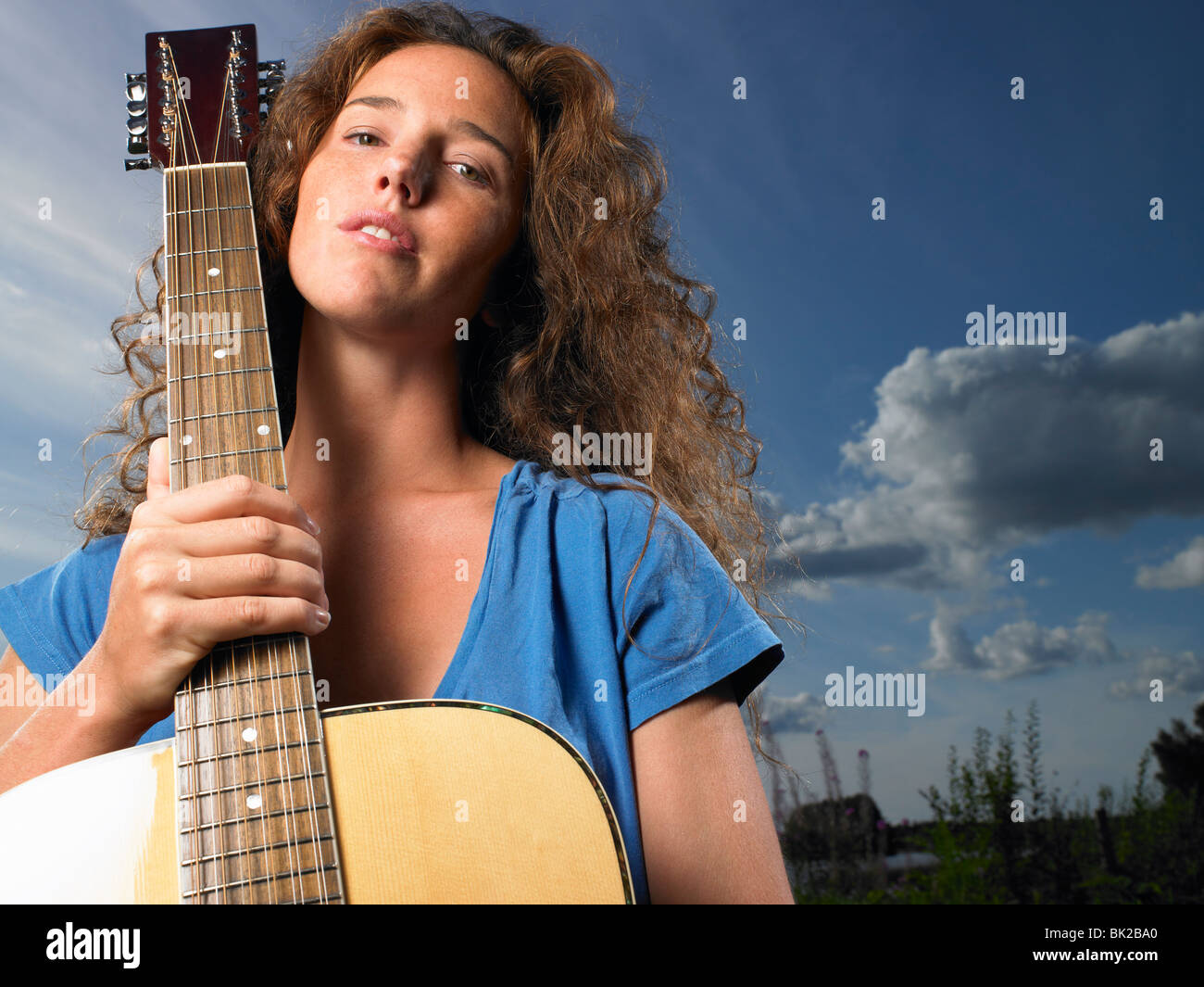 Woman holding her guitar Stock Photo - Alamy