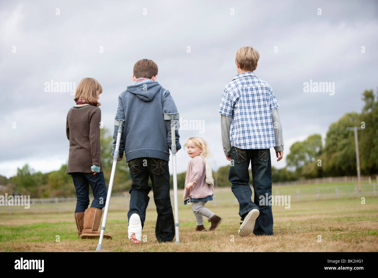 Boy on crutches with other children Stock Photo Alamy