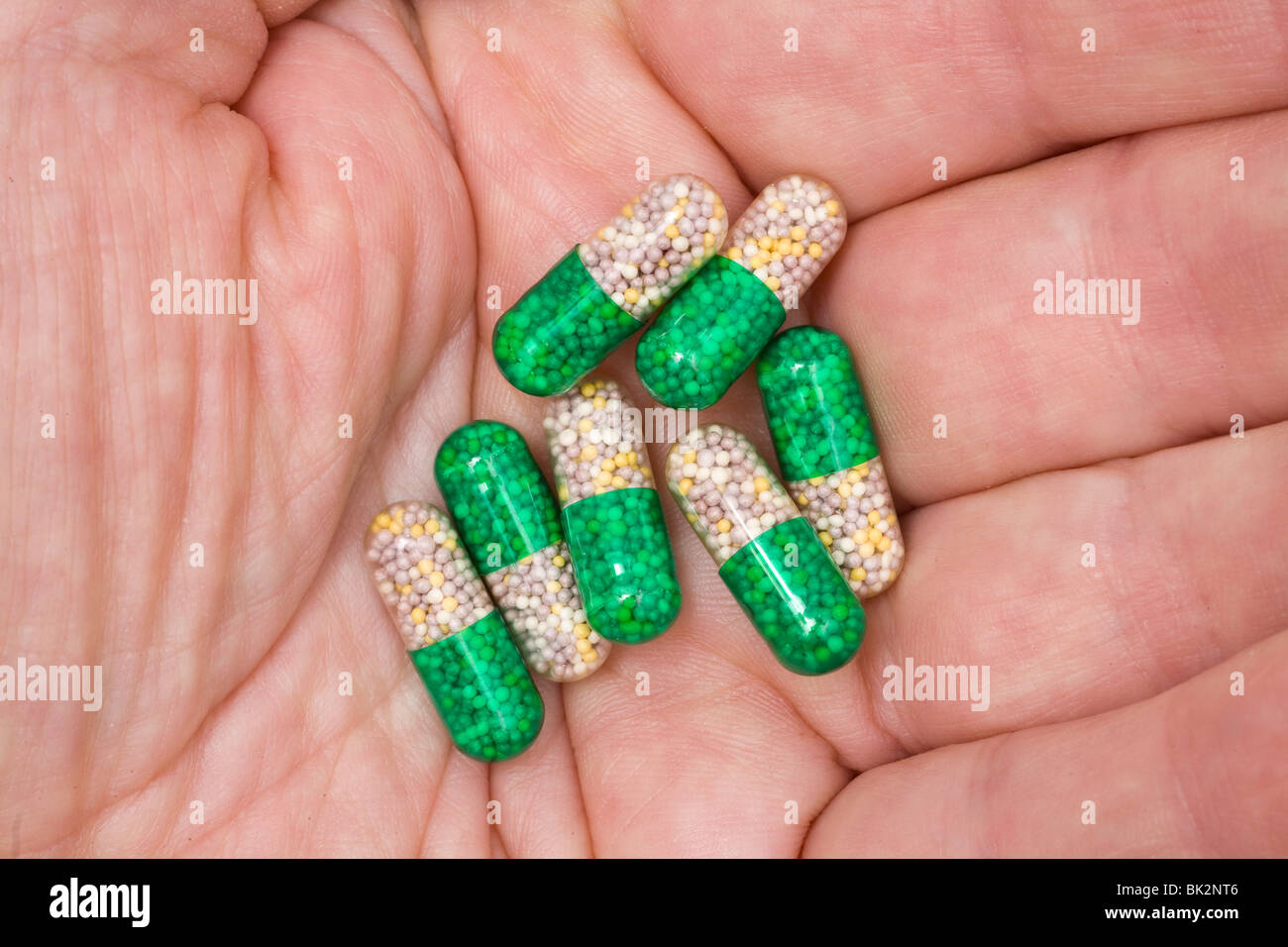 Hard-shelled medicinal capsules in the palm of a hand. Stock Photo
