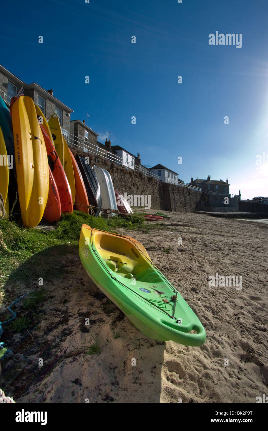 Canoes on the beach in Mousehole harbour, Cornwall, uk Stock Photo Alamy