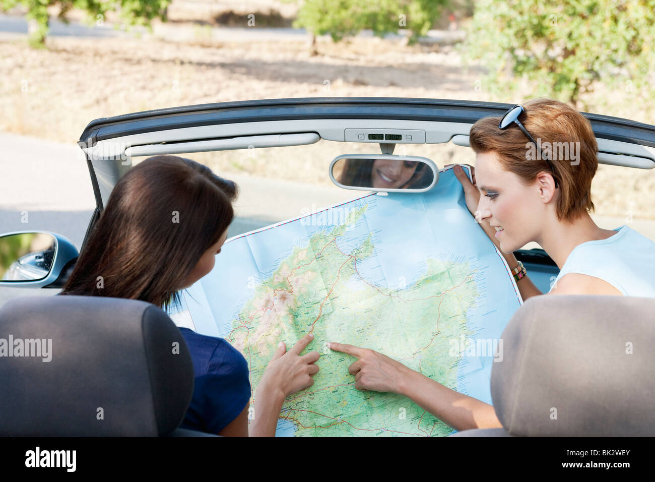 Two women reading a map in a car Stock Photo