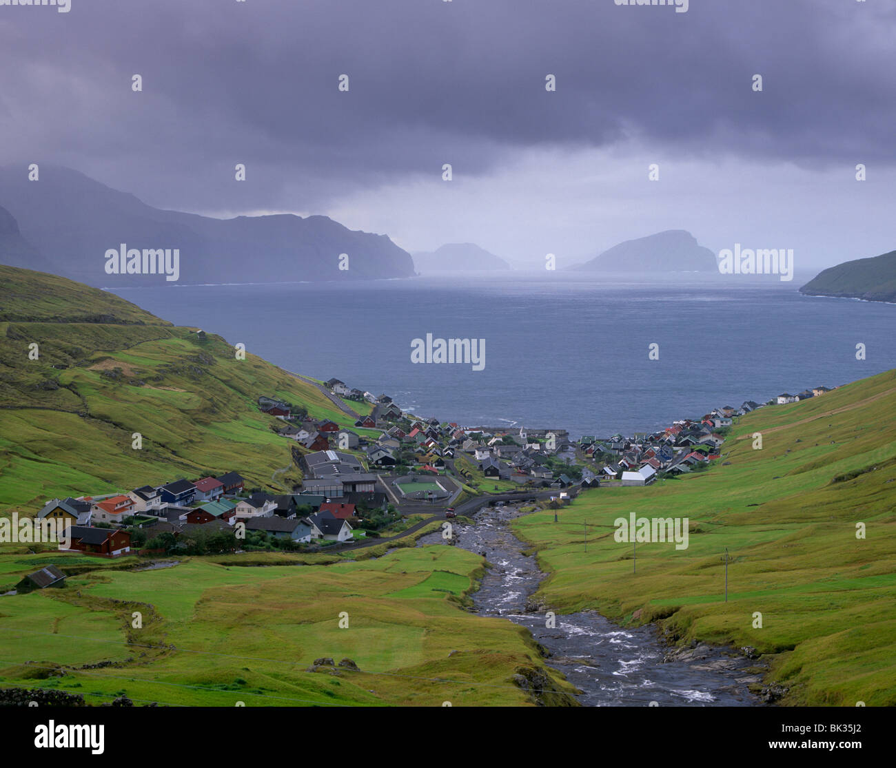 Village of Kvivik and Stora river, Streymoy coastline, Koltur and Hestur in the distance, Streymoy, Faroe Islands Stock Photo