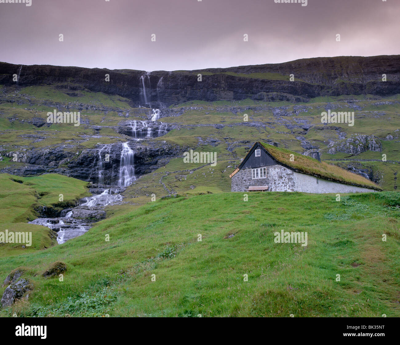 Traditional turf roofed farm building and waterfall, Saksun, Streymoy Island, Faroe Islands (Faroes), Denmark, Europe Stock Photo