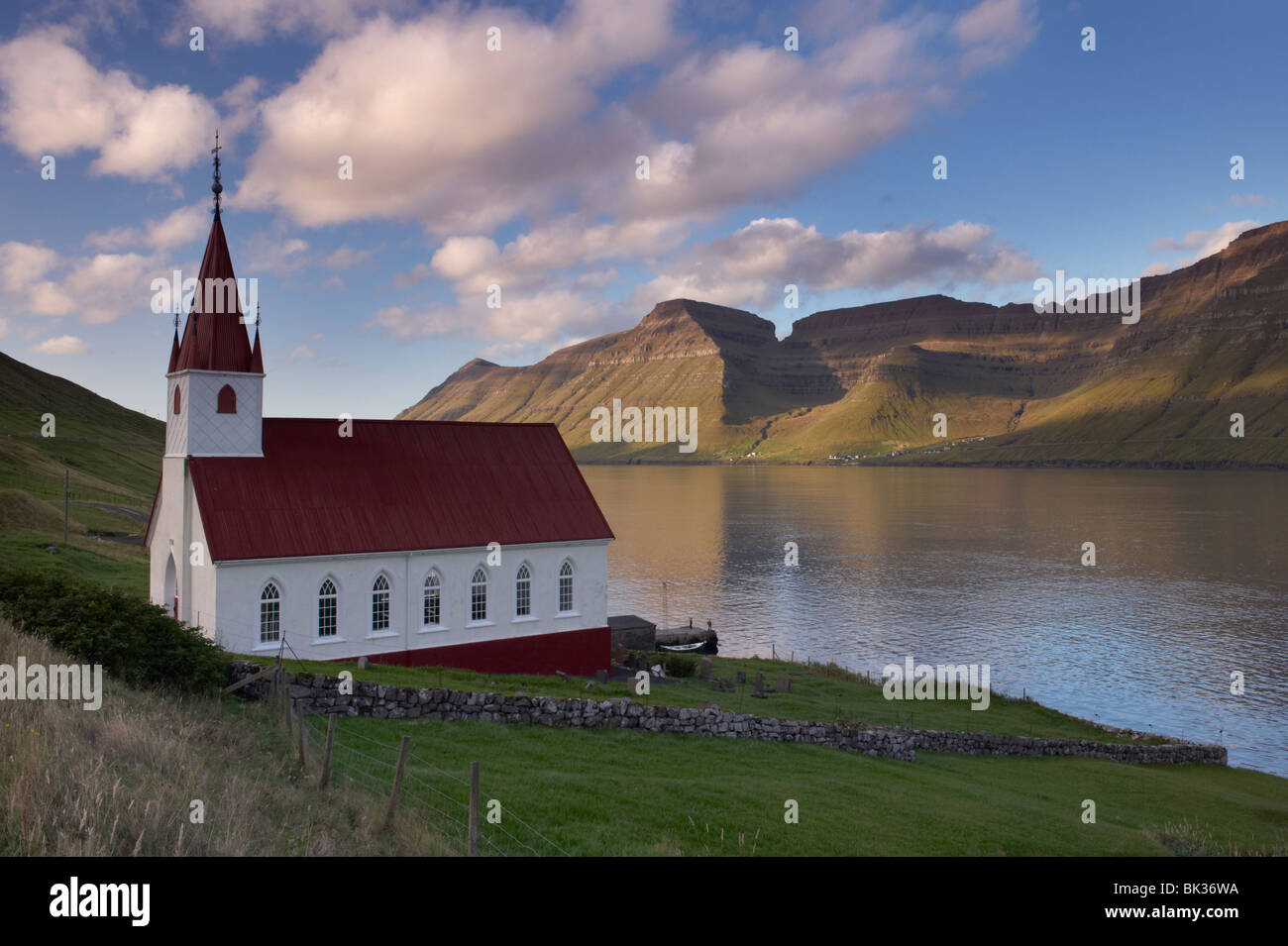 Church built in 1920 at Husar, Kalsoyarfjordur and Kunoy hills in the distance, Kalsoy, Nordoyar, Faroe Islands Stock Photo