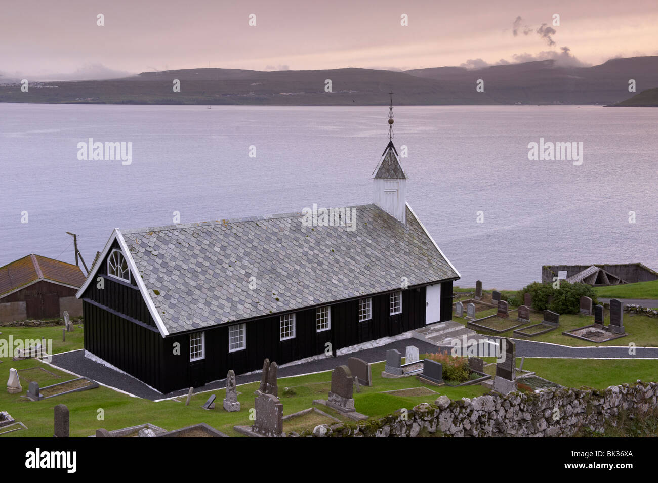 Wooden church at Nes dating from 1843, view across Tangafjordur towards Streymoy, Eysturoy Island, Faroe Islands Stock Photo