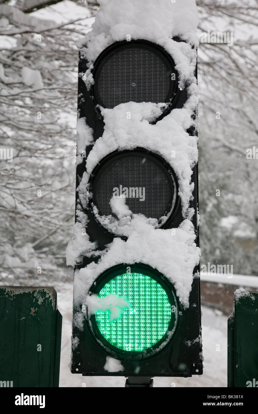Snow covered traffic lights showing green. Stock Photo