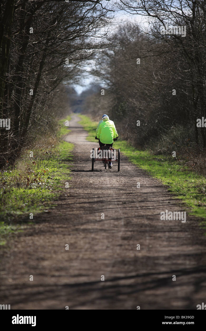 pensioners cycling on a tricycle on a country lane in the UK - upright image Stock Photo