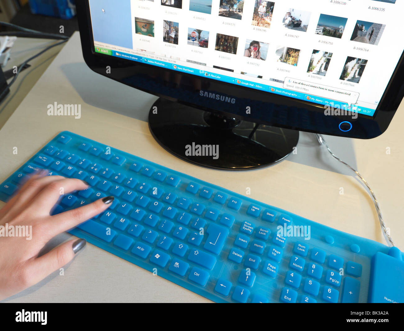 Hands On Blue Plastic Flexible Keyboard And Computer Monitor Stock
