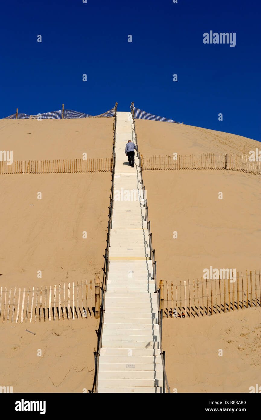 Man climbing steps leading up to Dunes du Pyla, Bay of Arcachon, Cote d'Argent, Aquitaine, France, Europe Stock Photo