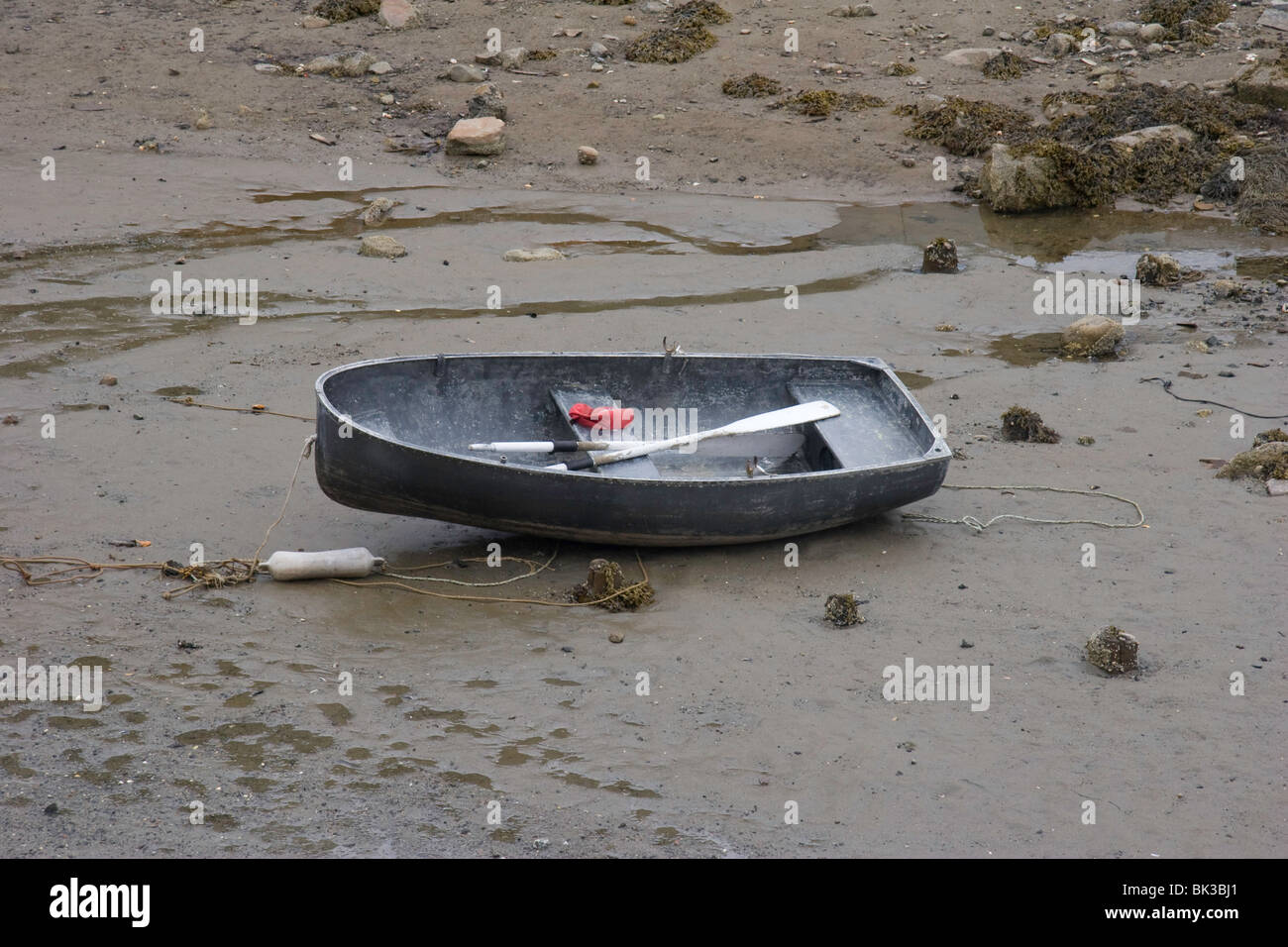 A dinghy is grounded out on the harbor bottom at low tide in Frenchboro on Long Island, Maine Stock Photo