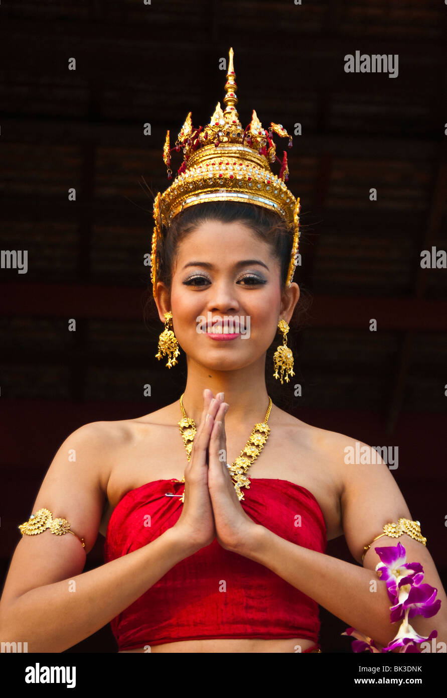 Young Thai woman in traditional costume and hands together in "wai