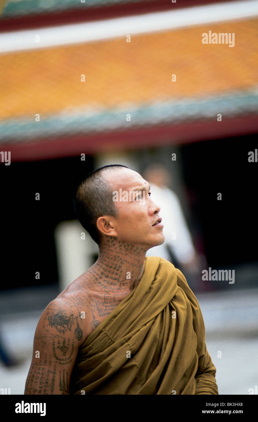Portrait of a Buddhist monk looking up at the Buddhist temple of Wat Arun in Bangkok, Thailand Stock Photo