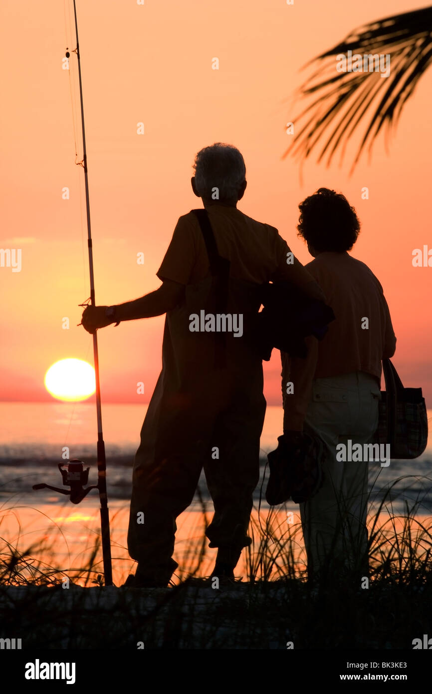 couple with a fishing pole Fishing pole couple silhouette beach hi-res stock photography and images