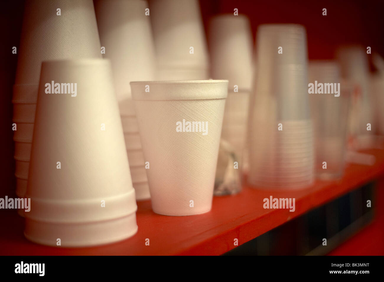 pile of new polystyrene cups sitting on a red shelf selective focus Stock Photo