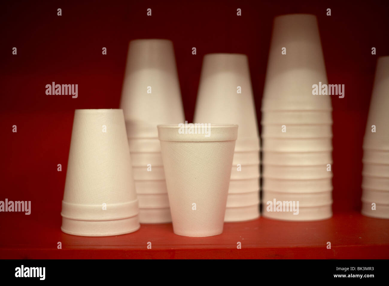 pile of new polystyrene cups sitting on a red shelf selective focus Stock Photo