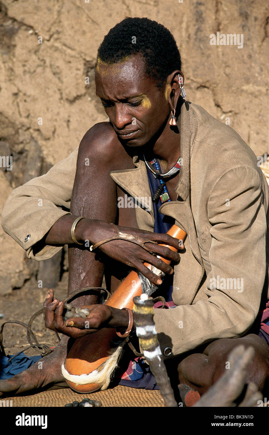 Maasai person with face paint and jewelry, holding a handful of rough gemstones in the Arusha District of Tanzania Stock Photo