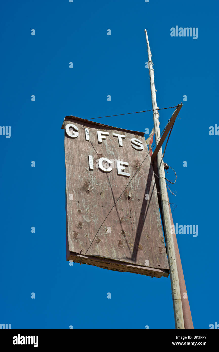 An old wood sign for gifts and ice fades in the intense desert sun at Three Rivers Trading Post, New Mexico. Stock Photo