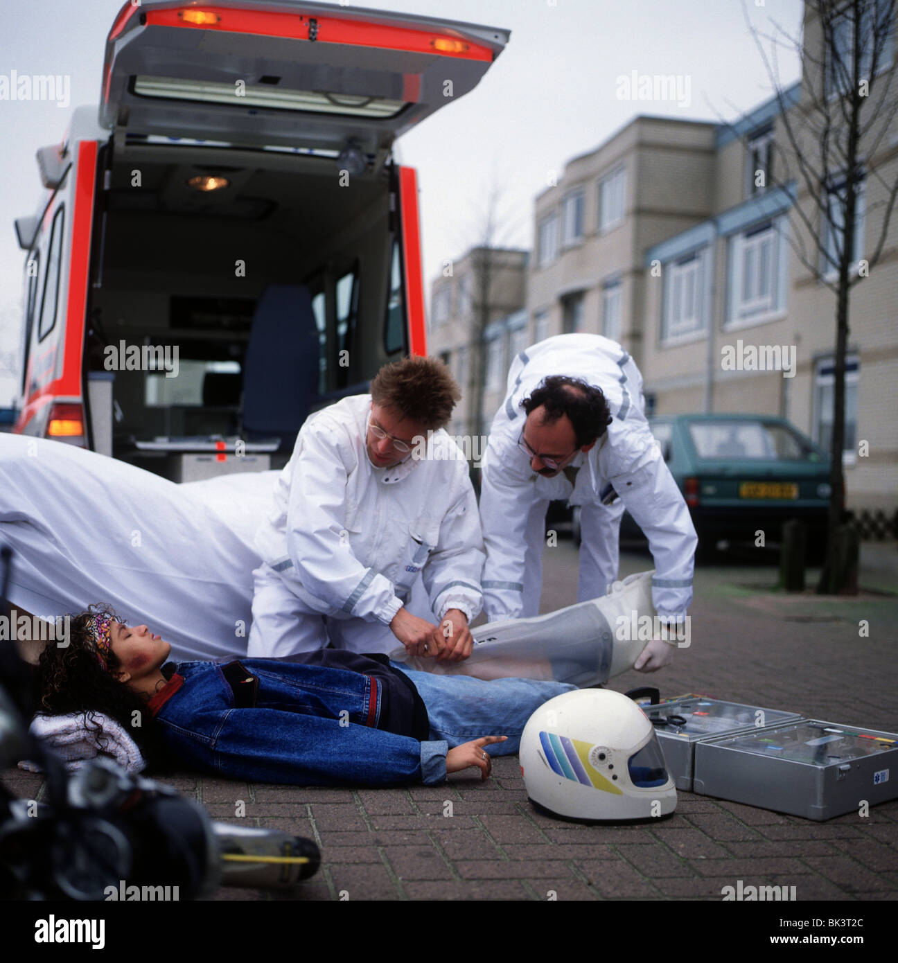 Ambulance and paramedics taking care of teenage girl after accident Stock Photo
