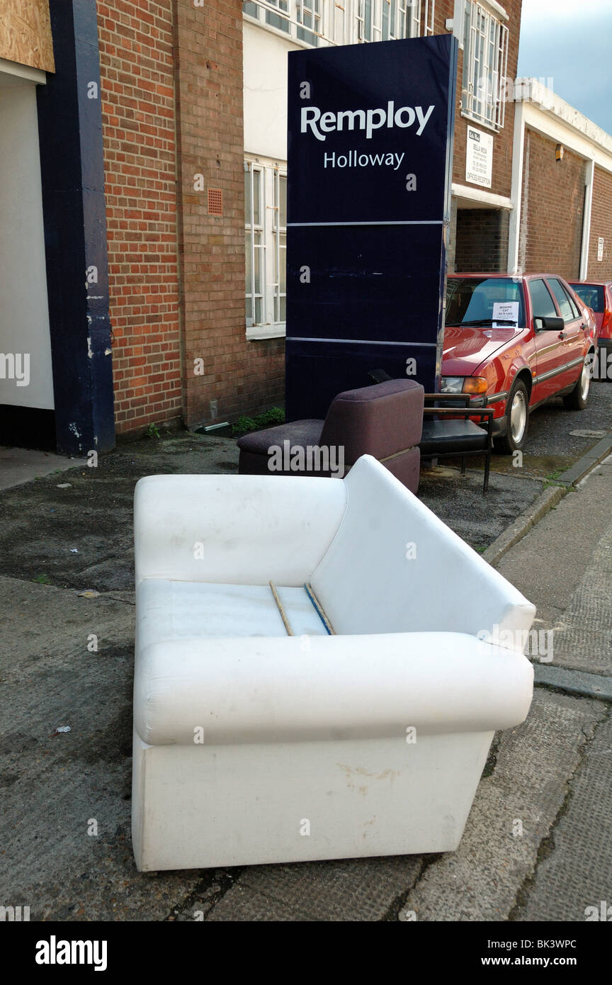 Sofa in street after squatters were evicted from the closed Remploy building Holloway London England UK Stock Photo