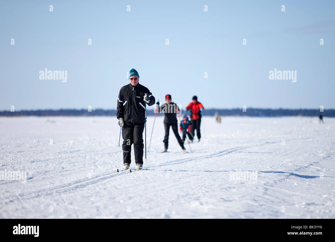 An elderly man skiing on a track made to sea ice , Finland Stock Photo