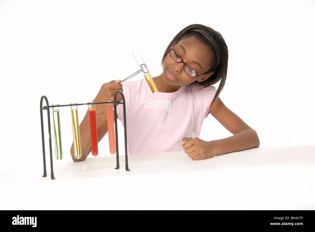 Ten year old girl, a student, doing a science experiment with beakers filled with colorful liquid. Stock Photo