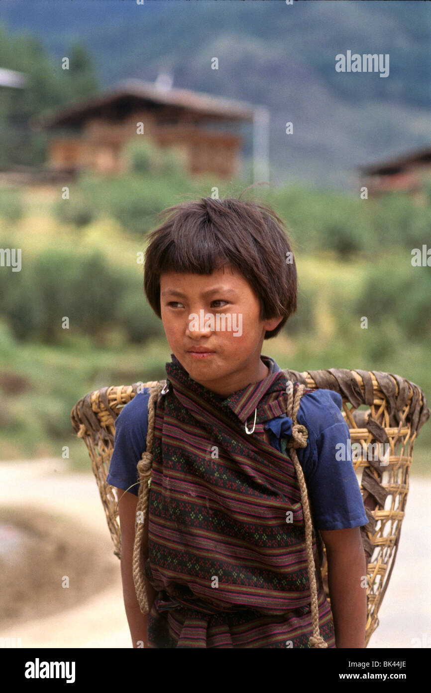 Portrait of young girl carrying a burden basket, Kingdom of Bhutan Stock Photo