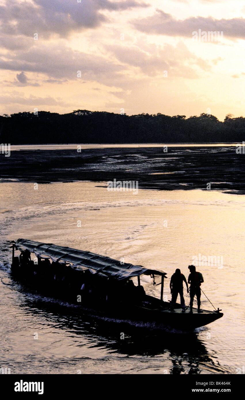 Covered tourist boat at sunset on the Aguarico River, Ecuador Stock Photo