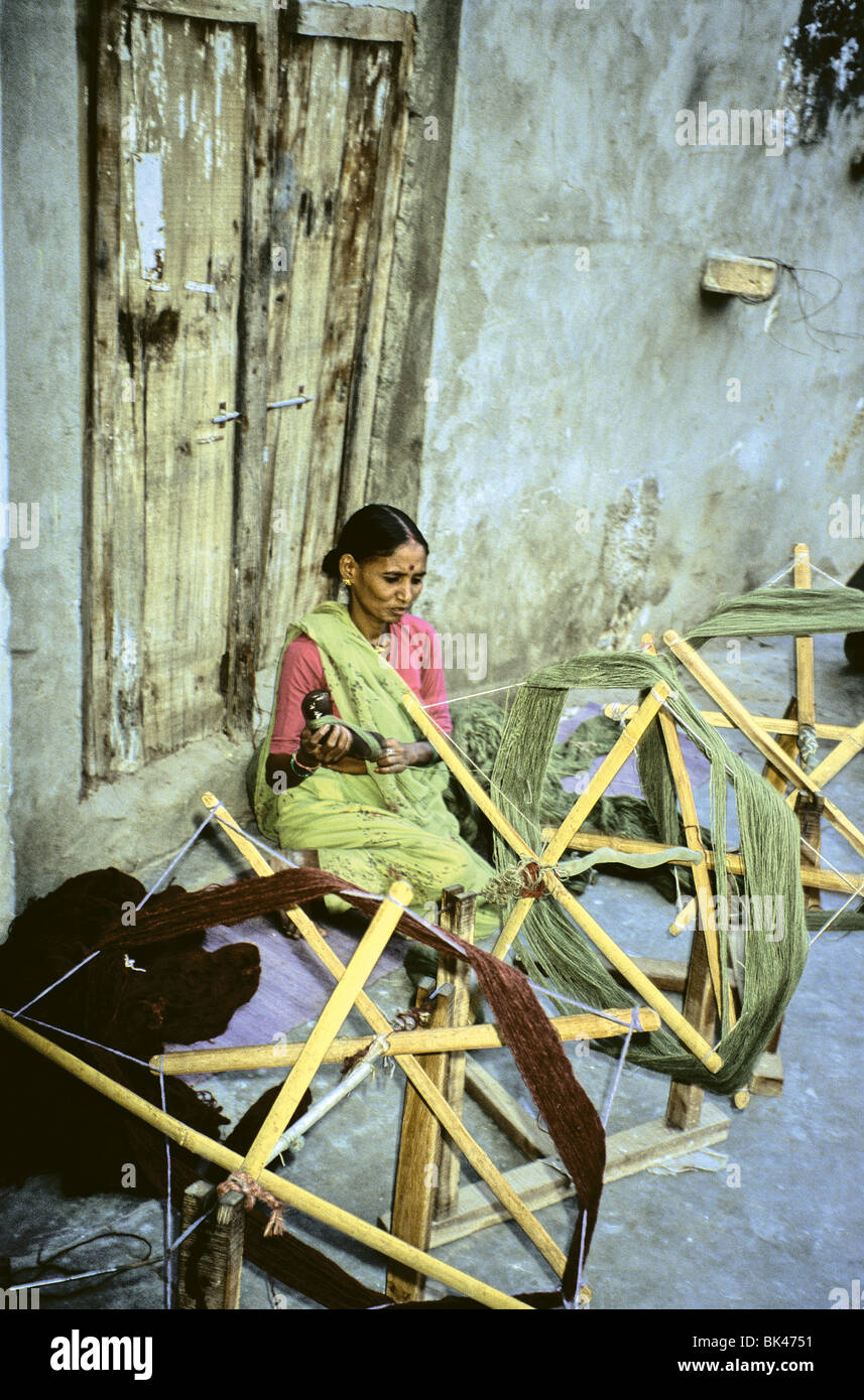 A woman working with handmade wooden frames for spinning thread in Jaipur, India Stock Photo