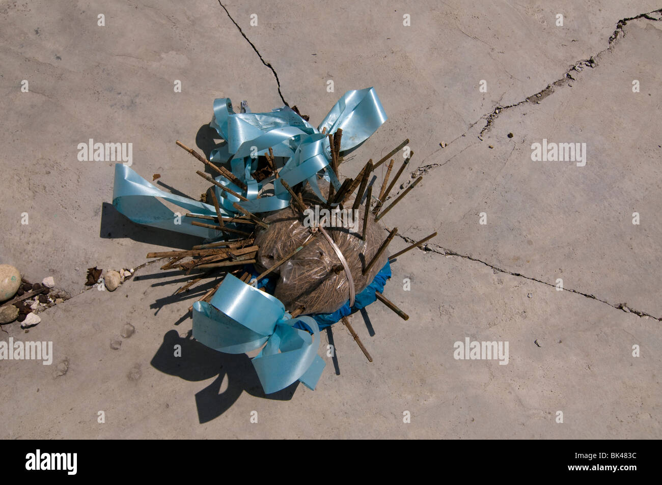 A voodoo ceremonial object is seen on a cracked gravestone in Haiti Stock Photo
