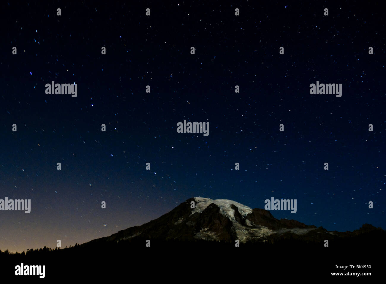 Night shot of Mount Rainier with stars in the night sky. Stock Photo