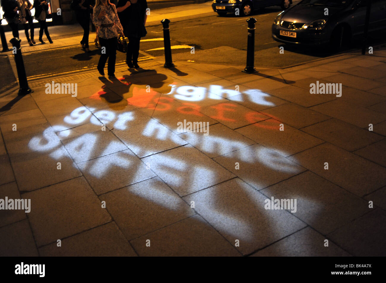 Night Safe Get Home Safely police signs beamed on to the street in Harrogate Yorkshire UK Stock Photo