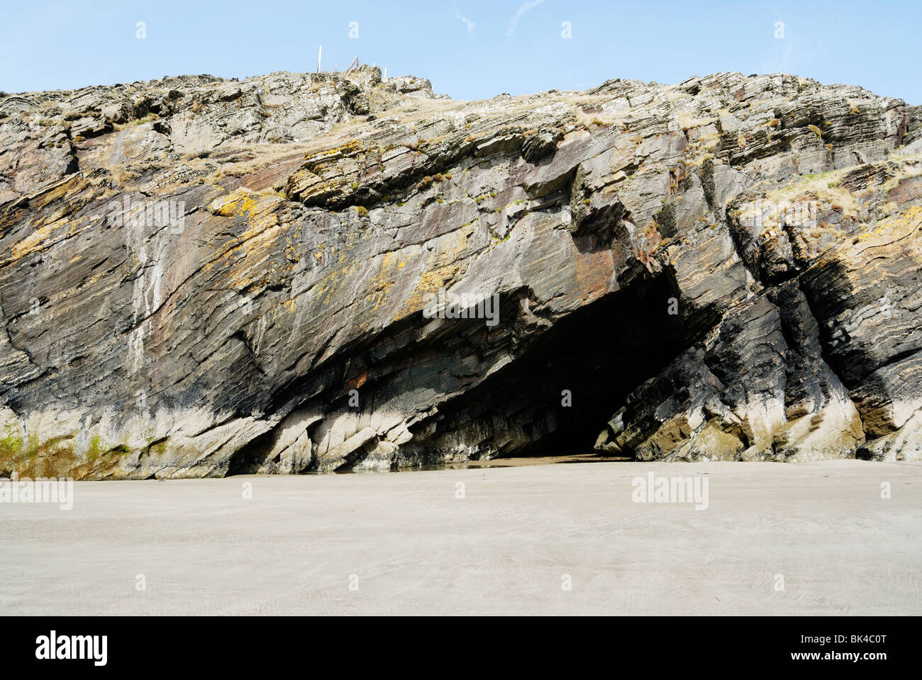 Sea cliff with caves formed by erosion of softer rock layers Stock
