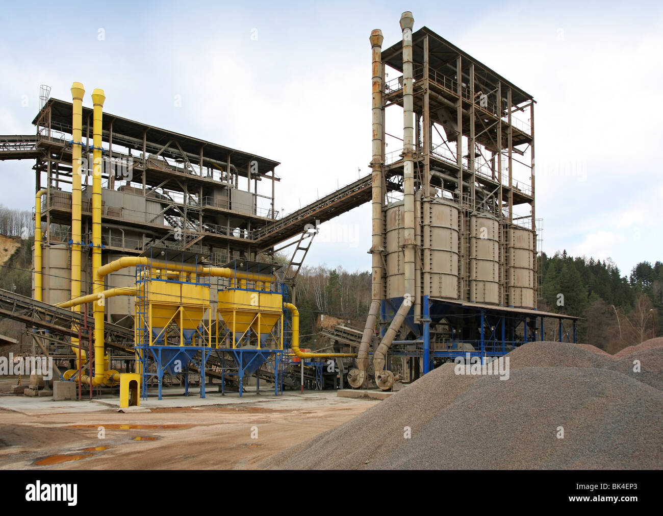 Stone quarry with silos, conveyor belts and piles of stones Stock Photo