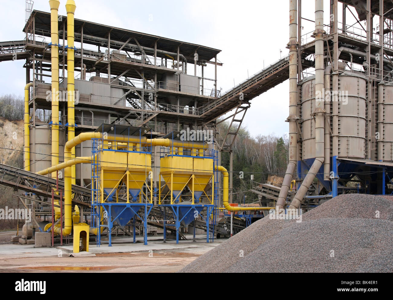 Stone quarry with silos, conveyor belts and piles of stones Stock Photo