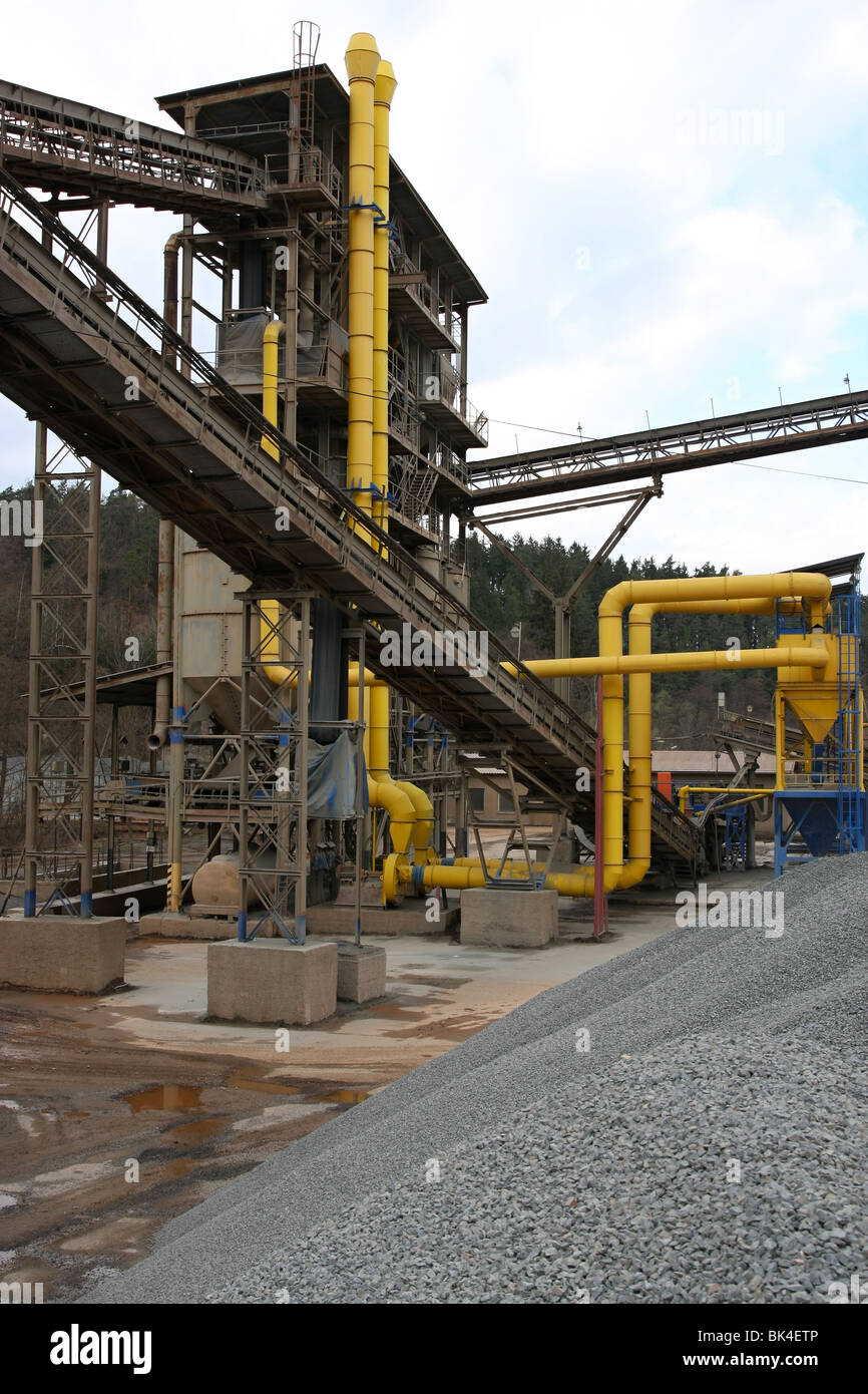 Stone quarry with silos, conveyor belts and piles of stones Stock Photo