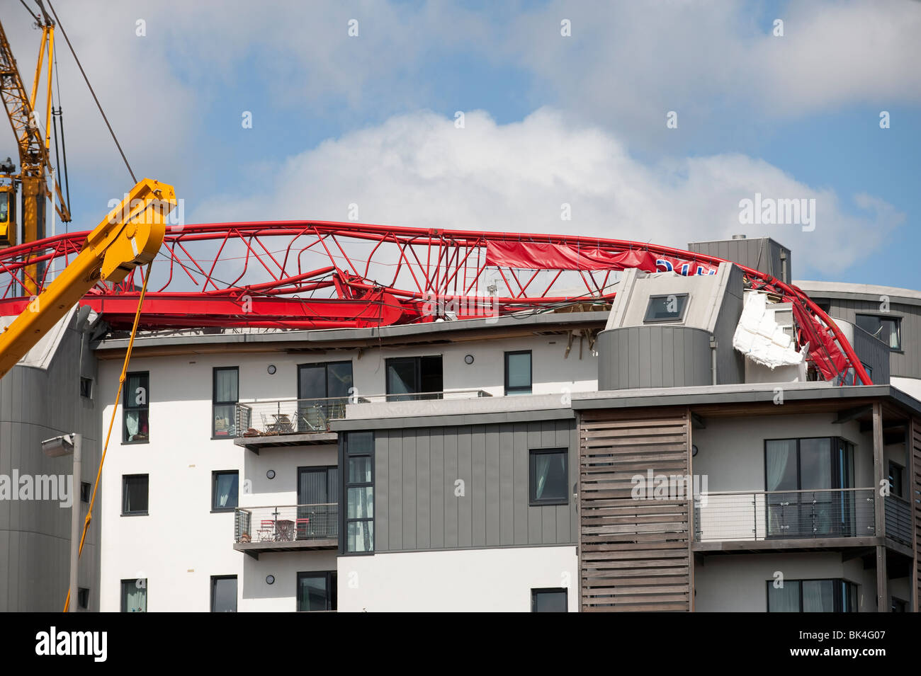 Tower crane collapsed fallen onto roof of apartment block being lifted