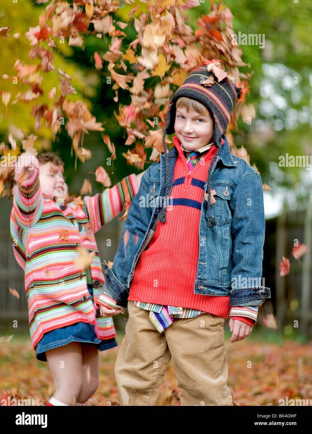 Brother and sister playing in autumn leaves Stock Photo - Alamy