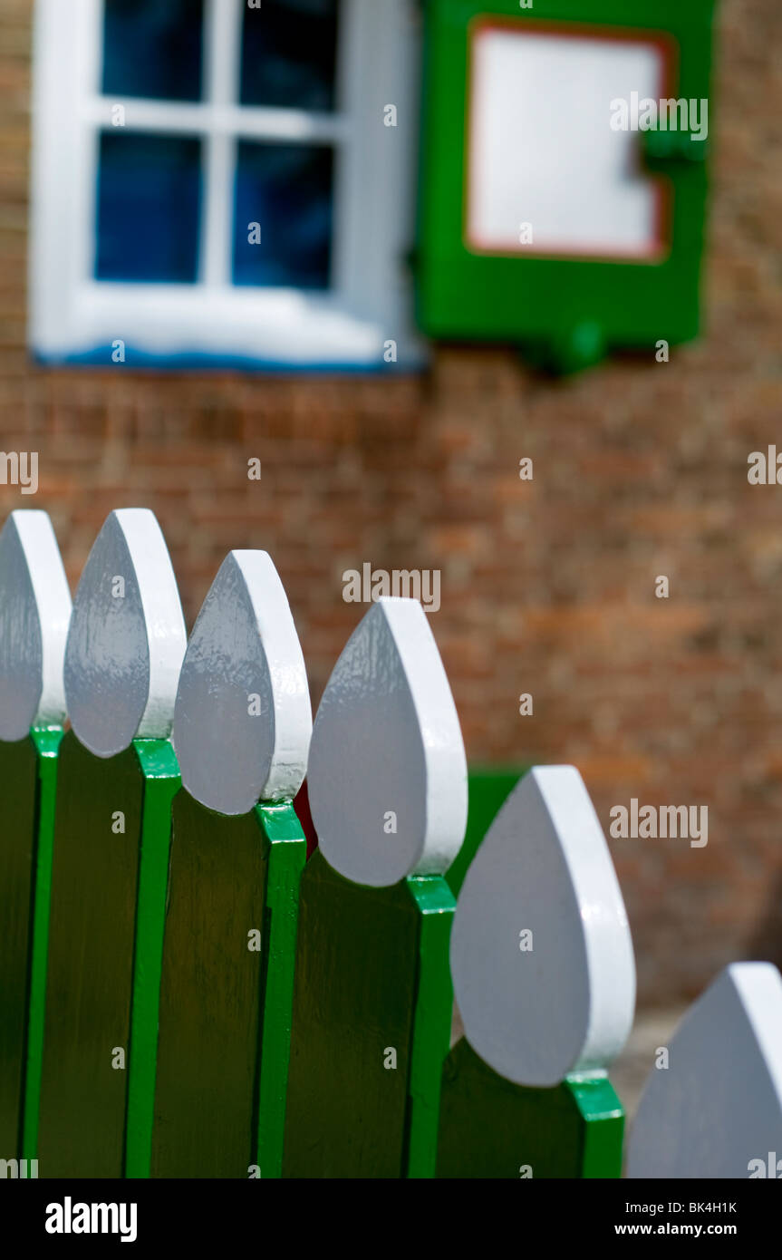 A green and white painted garden fence outside a house at the Open Air Museum in Arnhem, the Netherlands Stock Photo